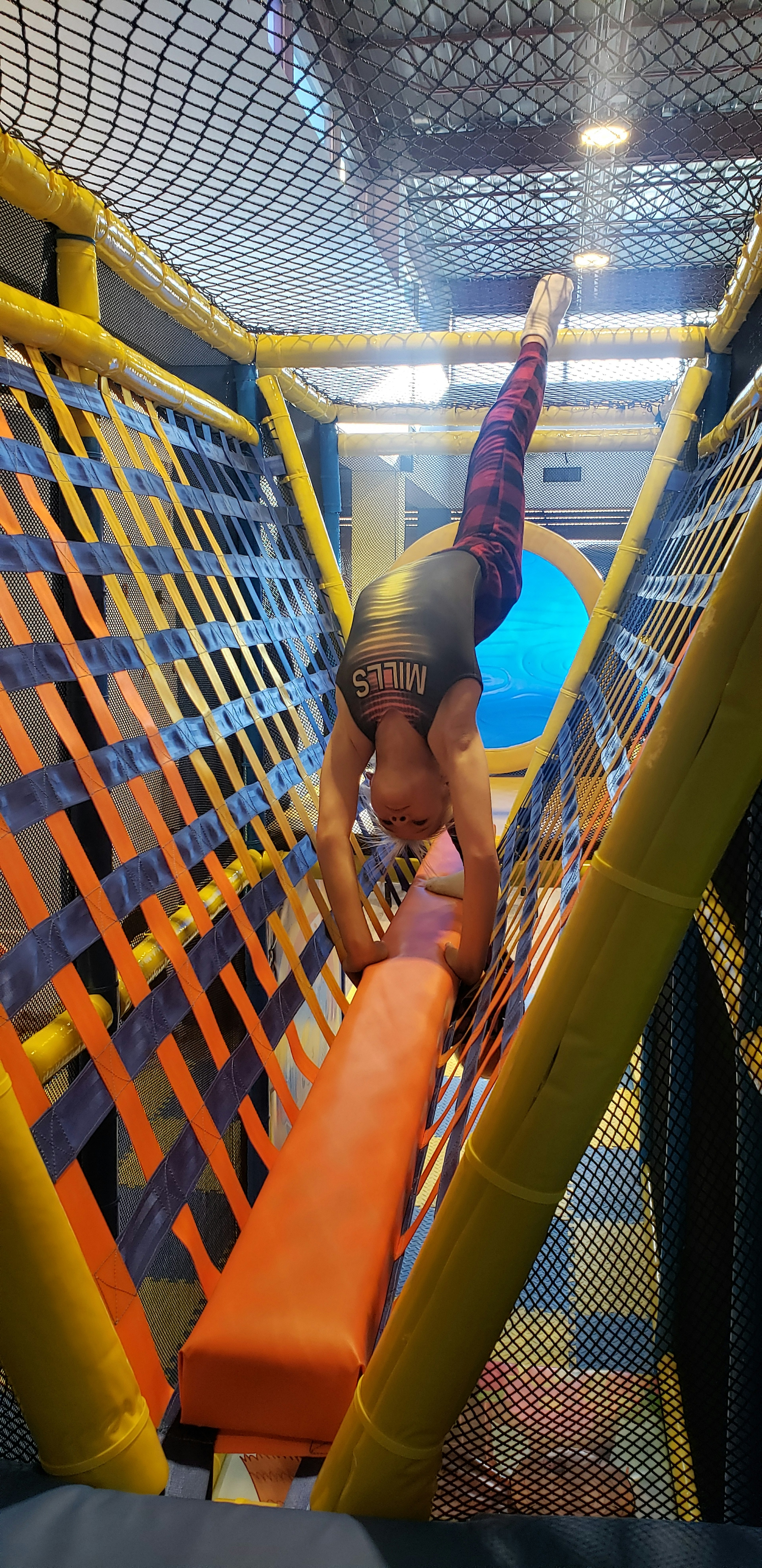 A handstand on the balance beam in the play structure.