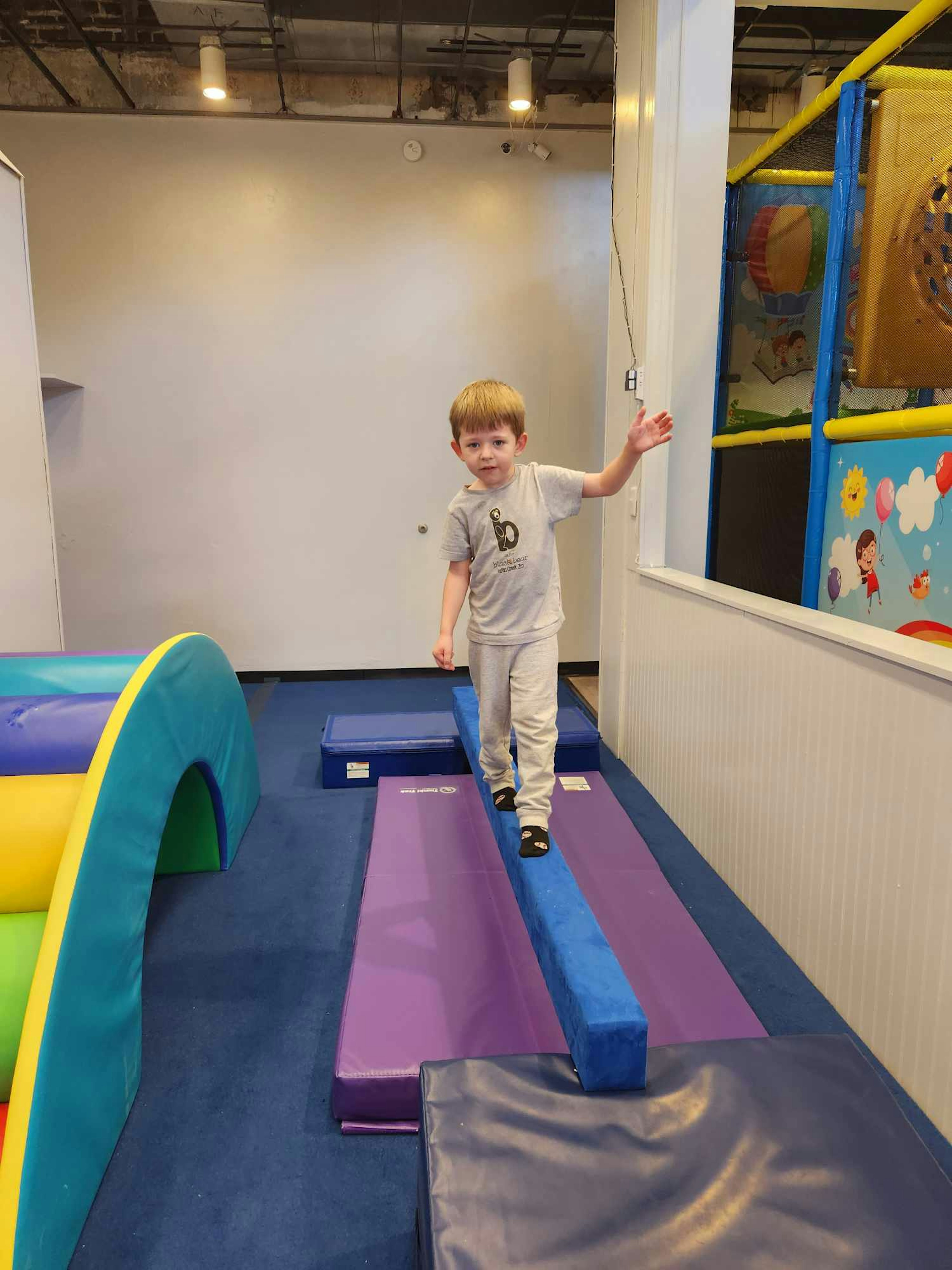 Walking the balance beam in the gymnastics room.