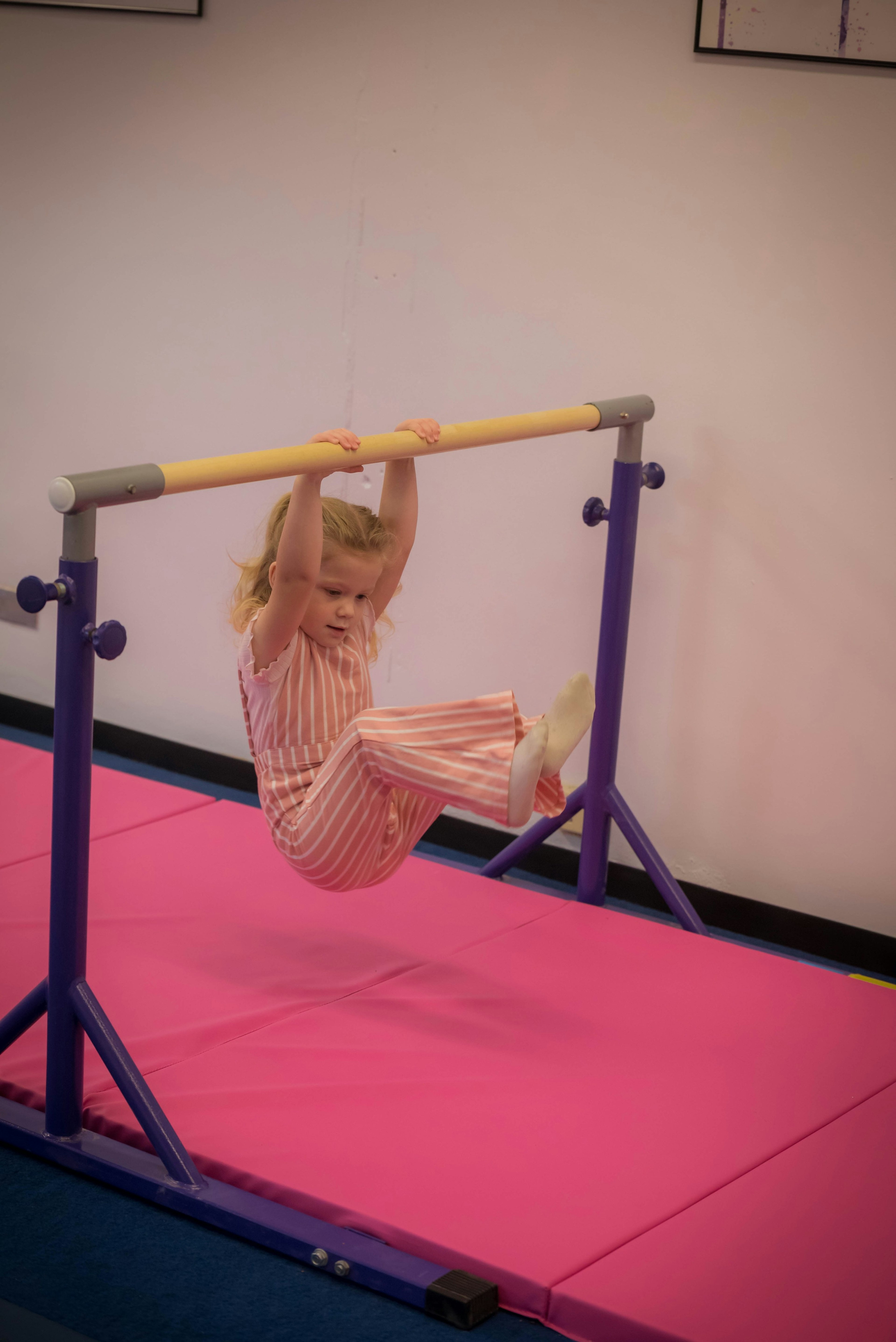 Swinging on a bar in the gymnastics room.